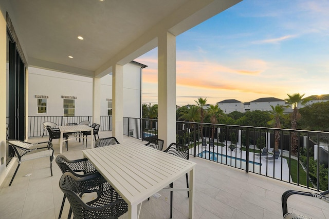336 S Holiday Rd, Destin, FL 32550 - balcony at dusk with outdoor dining area, view of pool area, and a patio