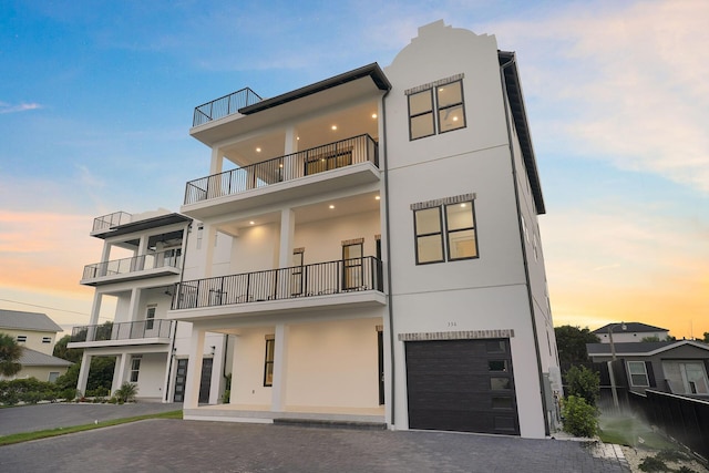 336 S Holiday Rd, Destin, FL 32550 - modern home with stucco siding, a balcony, decorative driveway, and a garage