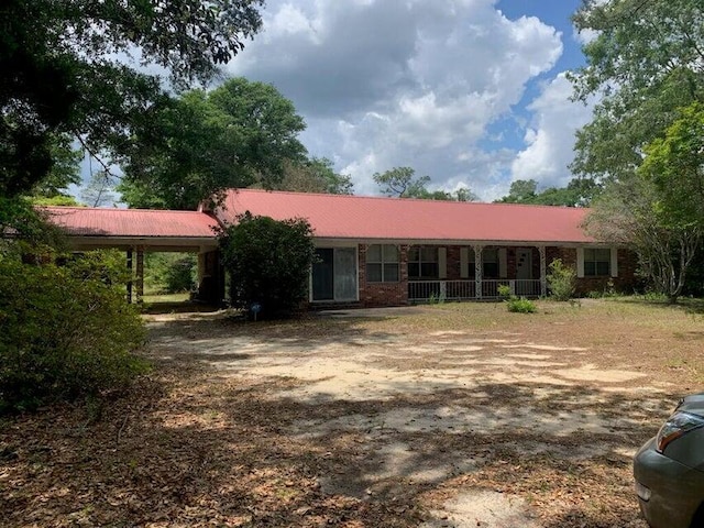 4099 State Highway 83, Defuniak Springs, FL 32433 - view of front of house with a carport, metal roof, and covered porch