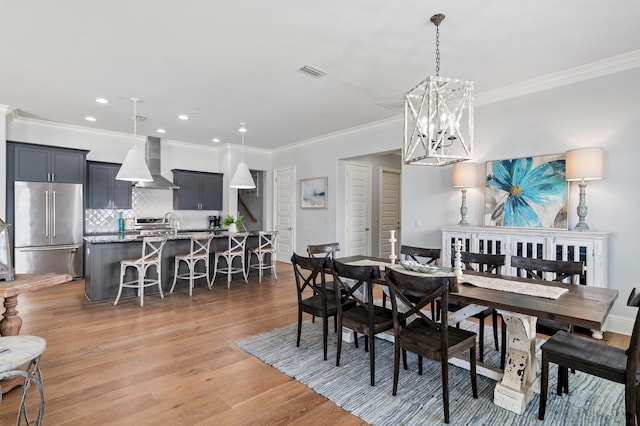 92 Maple St, Santa Rosa Beach, FL 32459 - dining space featuring a chandelier, crown molding, light wood finished floors, and recessed lighting