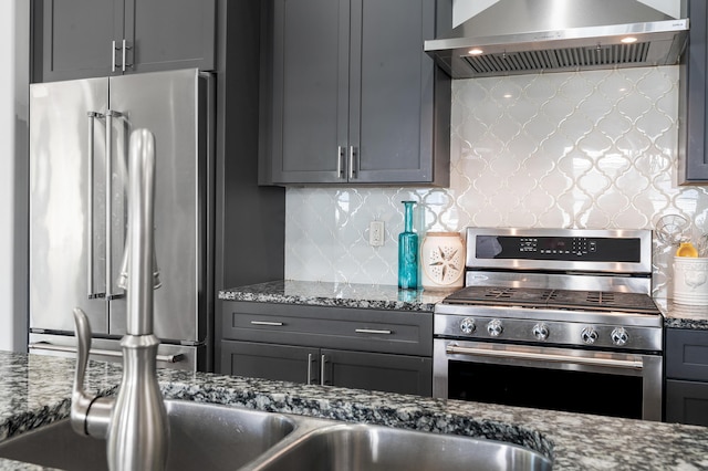 92 Maple St, Santa Rosa Beach, FL 32459 - kitchen with stainless steel appliances, wall chimney exhaust hood, decorative backsplash, dark stone counters, and gray cabinetry