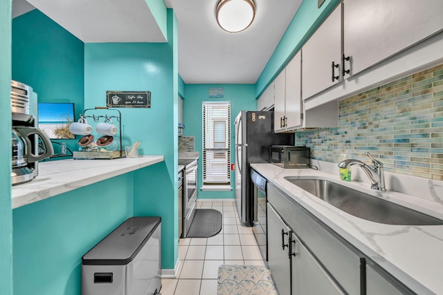 17614 Front Beach Rd Unit D13, Panama City Beach, FL 32413 - kitchen with a sink, black appliances, light tile patterned floors, tasteful backsplash, and white cabinetry