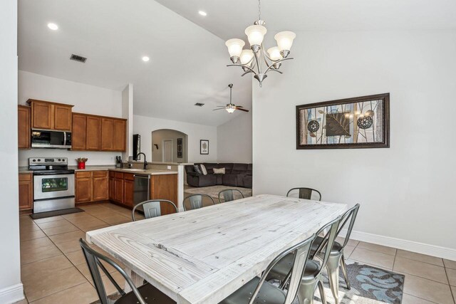 312 Scotch Pine Ln, Crestview, FL 32536 - dining area featuring lofted ceiling, light tile patterned floors, arched walkways, a chandelier, and baseboards