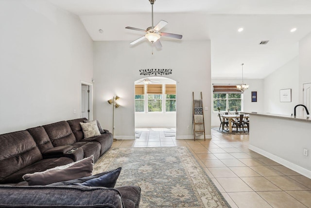 312 Scotch Pine Ln, Crestview, FL 32536 - living room with light tile patterned floors, high vaulted ceiling, a ceiling fan, baseboards, and a chandelier