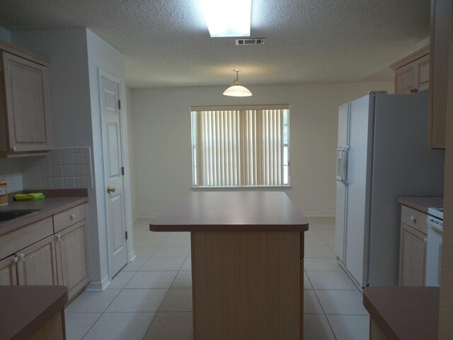 2095 Jessica Way, Navarre, FL 32566 - kitchen with a textured ceiling, light countertops, light tile patterned floors, a center island, and hanging light fixtures