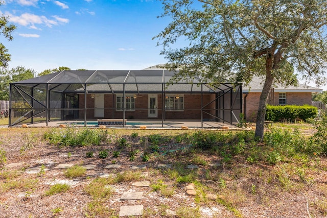 207 E Shipwreck Rd, Santa Rosa Beach, FL 32459 - rear view of property with brick siding, a patio area, and glass enclosure
