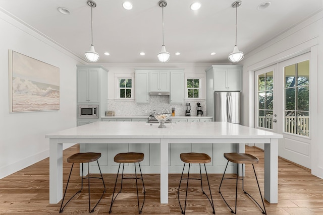 515 Seacrest Dr, Inlet Beach, FL 32461 - kitchen with stainless steel appliances, crown molding, light countertops, backsplash, and a large island with sink
