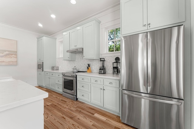515 Seacrest Dr, Inlet Beach, FL 32461 - kitchen featuring stainless steel appliances, under cabinet range hood, crown molding, light wood finished floors, and light countertops