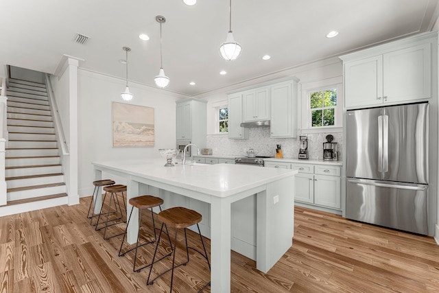 515 Seacrest Dr, Inlet Beach, FL 32461 - kitchen with appliances with stainless steel finishes, ornamental molding, light wood-type flooring, backsplash, and an island with sink