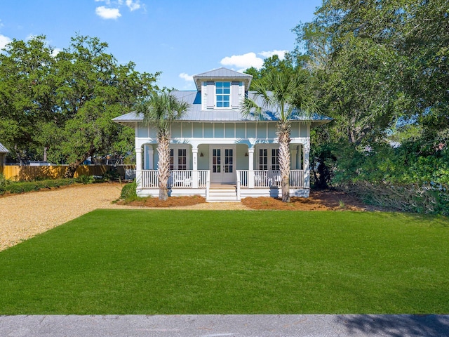 515 Seacrest Dr, Inlet Beach, FL 32461 - view of front of home with french doors, covered porch, a front yard, metal roof, and board and batten siding