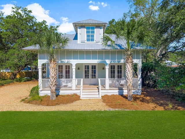 515 Seacrest Dr, Inlet Beach, FL 32461 - view of front of property featuring french doors, a porch, a front yard, metal roof, and board and batten siding