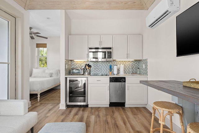 106 N Winston Ln, Inlet Beach, FL 32461 - kitchen with stainless steel appliances, beverage cooler, an AC wall unit, tasteful backsplash, and white cabinets