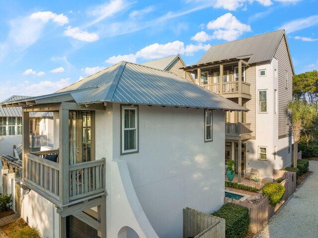 106 N Winston Ln, Inlet Beach, FL 32461 - view of side of home featuring stucco siding, a balcony, and a metal roof