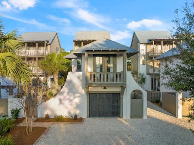 106 N Winston Ln, Inlet Beach, FL 32461 - view of front facade with stucco siding, gravel driveway, an attached garage, and a balcony
