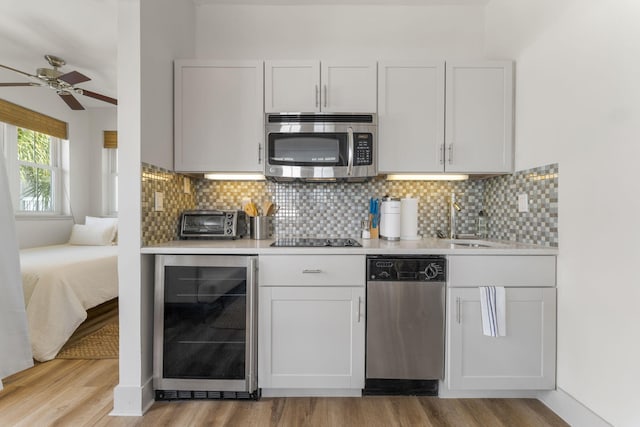 106 N Winston Ln, Inlet Beach, FL 32461 - kitchen featuring wine cooler, stainless steel appliances, light countertops, light wood-style flooring, and tasteful backsplash