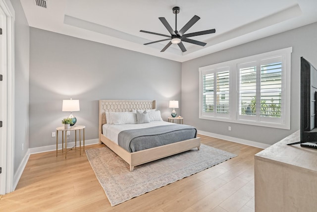 425 W Lafayette, Inlet Beach, FL 32461 - bedroom featuring a tray ceiling, light wood-style floors, baseboards, and ceiling fan