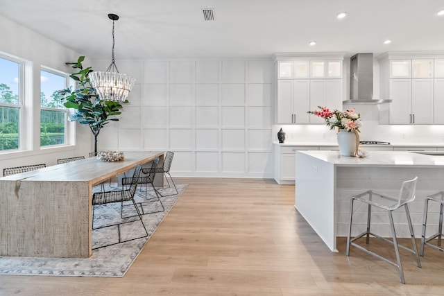 425 W Lafayette, Inlet Beach, FL 32461 - kitchen featuring wall chimney exhaust hood, light wood-type flooring, light countertops, a kitchen breakfast bar, and recessed lighting
