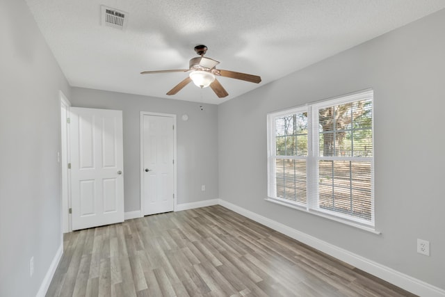 319 Jones Rd, Crestview, FL 32536 - unfurnished bedroom featuring light wood-type flooring, baseboards, ceiling fan, and a textured ceiling