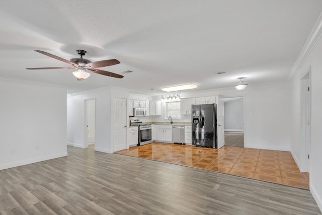 319 Jones Rd, Crestview, FL 32536 - kitchen with appliances with stainless steel finishes, white cabinetry, light wood-style floors, a ceiling fan, and light countertops