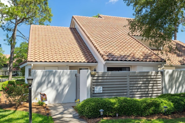 5144 Beachwalk Cir, Miramar Beach, FL 32550 - view of front facade featuring stucco siding, fence, and a tile roof