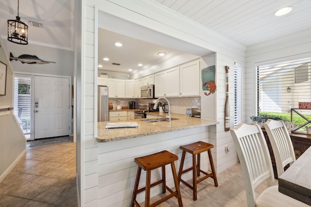 5144 Beachwalk Cir, Miramar Beach, FL 32550 - kitchen with ornamental molding, appliances with stainless steel finishes, a sink, plenty of natural light, and light stone counters