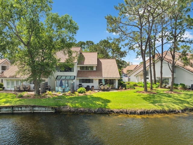 5144 Beachwalk Cir, Miramar Beach, FL 32550 - back of house with a tile roof, a patio, a water view, a yard, and stucco siding