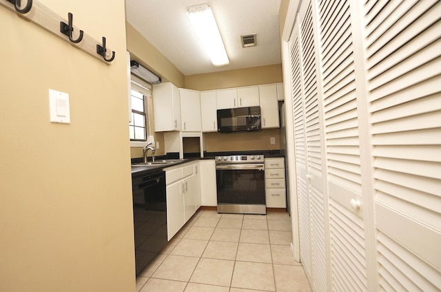 118 5th Ave Unit 118, Shalimar, FL 32579 - kitchen featuring black appliances, dark countertops, white cabinetry, light tile patterned floors, and a sink