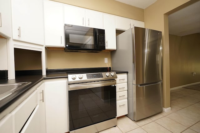 118 5th Ave Unit 118, Shalimar, FL 32579 - kitchen featuring appliances with stainless steel finishes, light tile patterned floors, white cabinets, and dark countertops