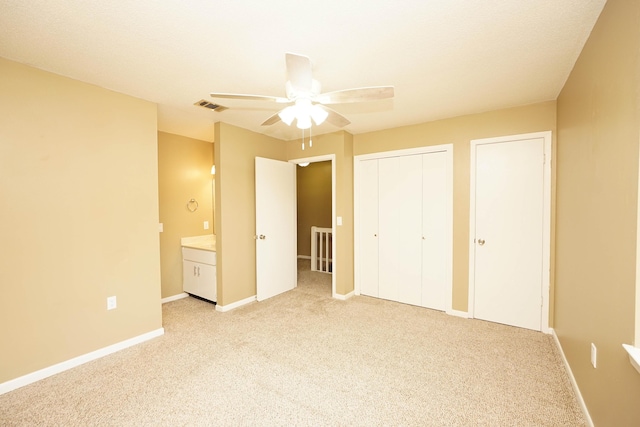 118 5th Ave Unit 118, Shalimar, FL 32579 - unfurnished bedroom featuring light carpet, baseboards, a ceiling fan, and multiple closets