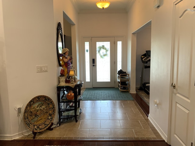 entrance foyer with crown molding and baseboards