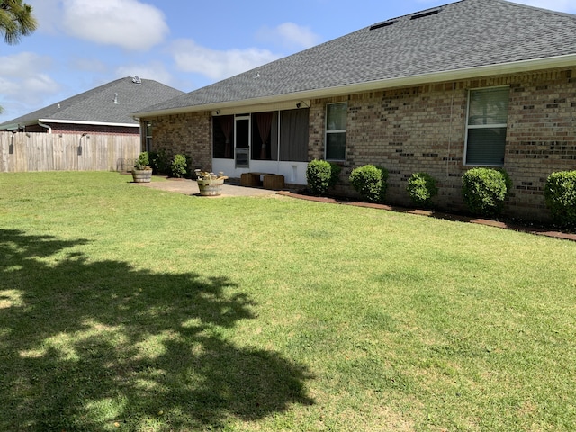 back of property featuring roof with shingles, brick siding, and a patio