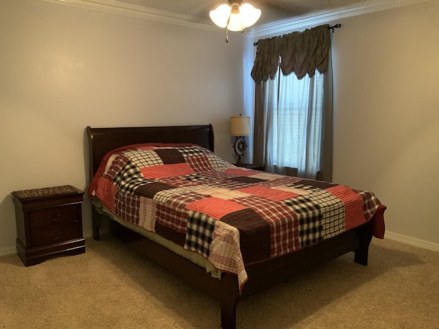 carpeted bedroom featuring ornamental molding, baseboards, and a ceiling fan