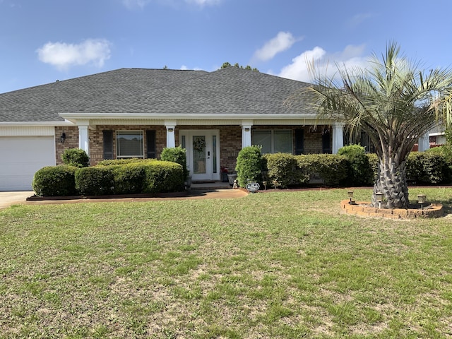 view of front of house with an attached garage, a front yard, brick siding, and a shingled roof
