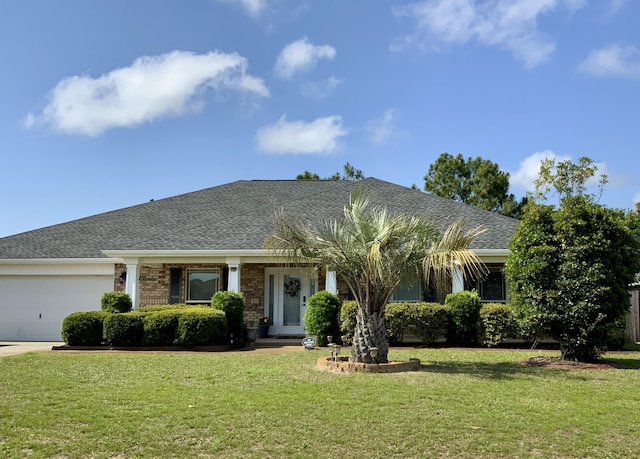 view of front of home with an attached garage, a front lawn, and roof with shingles