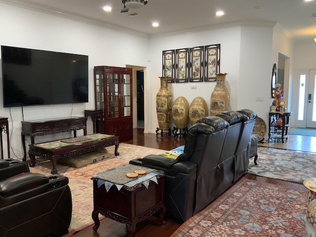 living area with wood finished floors, ornamental molding, and recessed lighting