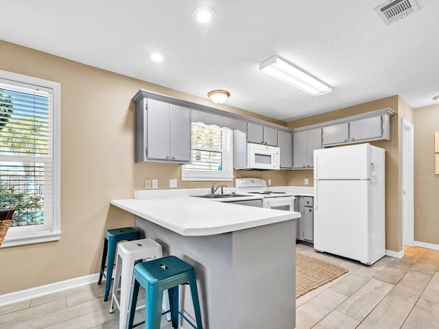 11 Beachside Dr Unit 1211, Santa Rosa Beach, FL 32459 - kitchen with white appliances, gray cabinetry, a peninsula, light countertops, and recessed lighting