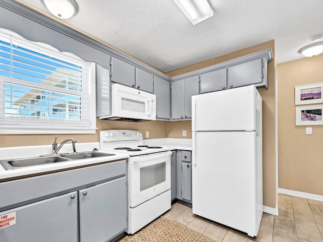11 Beachside Dr Unit 1211, Santa Rosa Beach, FL 32459 - kitchen with white appliances, gray cabinetry, a sink, a textured ceiling, and light countertops