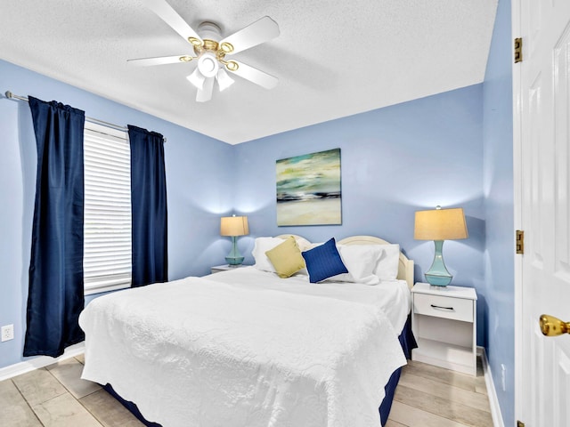 11 Beachside Dr Unit 1211, Santa Rosa Beach, FL 32459 - bedroom with a textured ceiling, baseboards, and ceiling fan