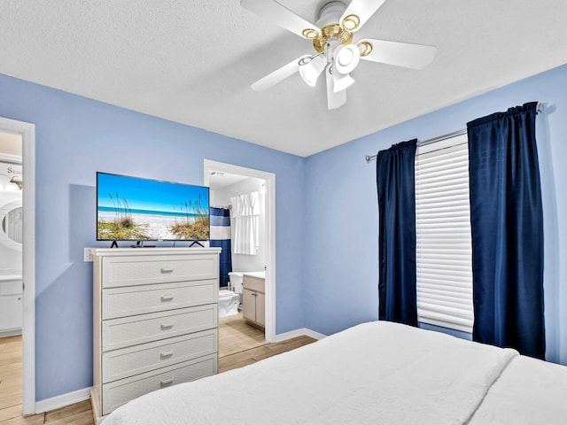 11 Beachside Dr Unit 1211, Santa Rosa Beach, FL 32459 - bedroom featuring light wood-style flooring, baseboards, connected bathroom, ceiling fan, and a textured ceiling