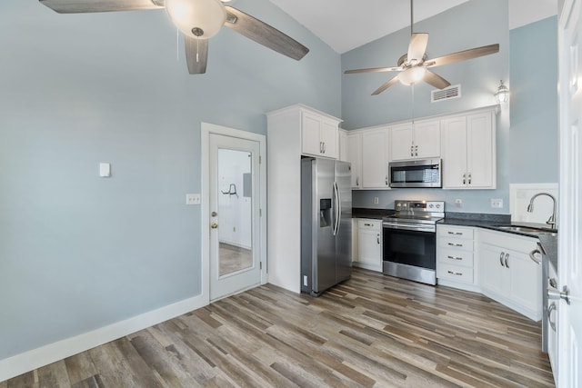 2512 Georgetown Ln, Fort Walton Beach, FL 32547 - kitchen with stainless steel appliances, a sink, high vaulted ceiling, ceiling fan, and dark countertops