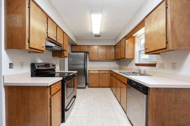 136 Midland Ct, Niceville, FL 32578 - kitchen with appliances with stainless steel finishes, under cabinet range hood, a sink, light tile patterned flooring, and brown cabinetry