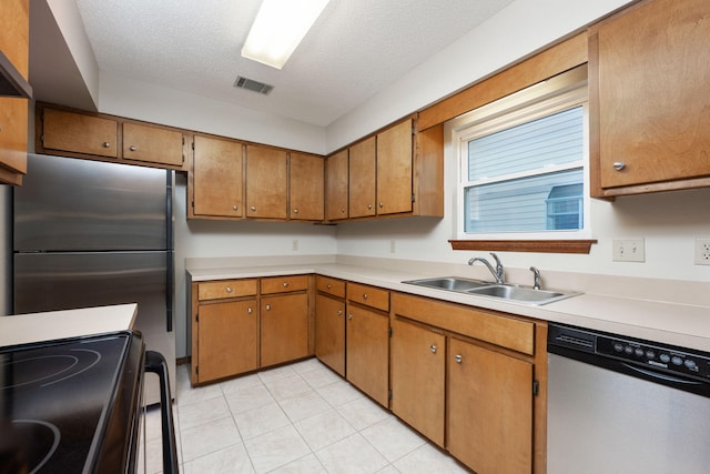136 Midland Ct, Niceville, FL 32578 - kitchen with appliances with stainless steel finishes, a sink, light countertops, light tile patterned floors, and a textured ceiling