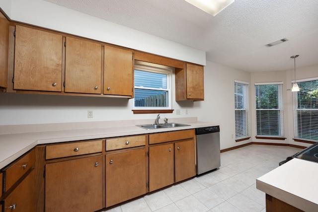 136 Midland Ct, Niceville, FL 32578 - kitchen with stainless steel dishwasher, a sink, a textured ceiling, light tile patterned floors, and light countertops
