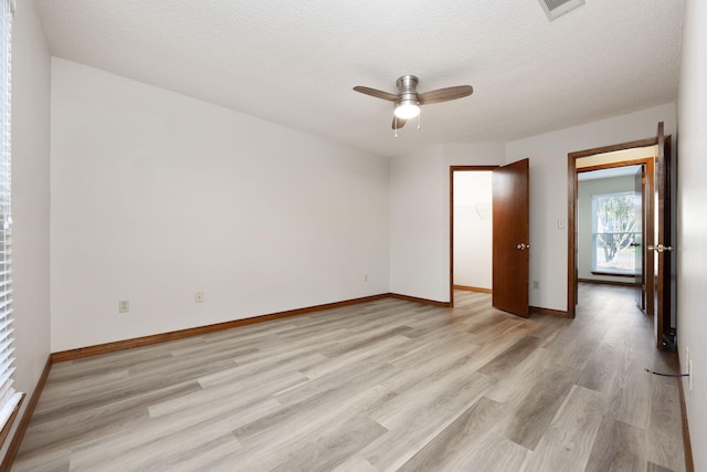 136 Midland Ct, Niceville, FL 32578 - empty room with light wood-style floors, ceiling fan, baseboards, and a textured ceiling