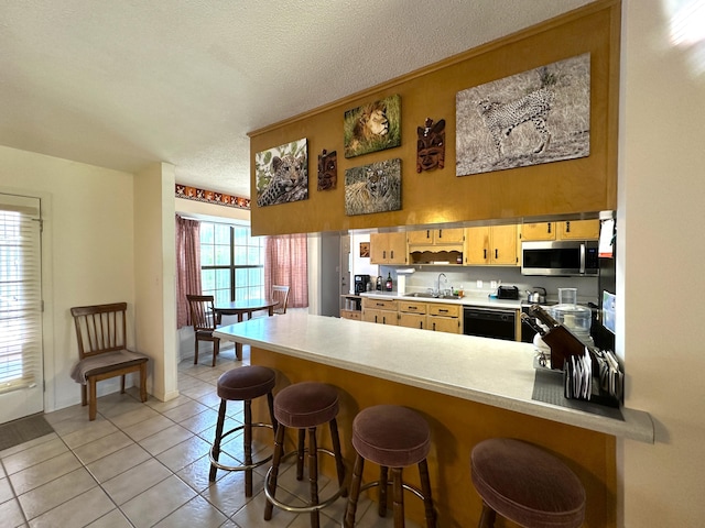 3864 Bear Head Rd, Crestview, FL 32539 - kitchen with a sink, a peninsula, stainless steel microwave, dishwasher, and light tile patterned floors
