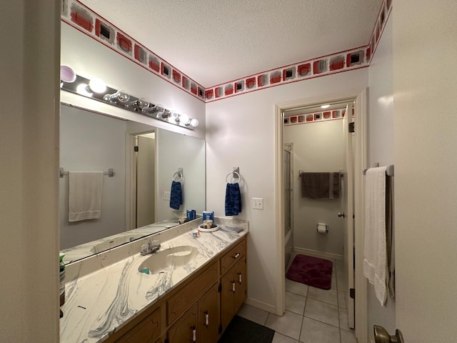 3864 Bear Head Rd, Crestview, FL 32539 - full bath with tile patterned floors, vanity, a textured ceiling, combined bath / shower with glass door, and baseboards