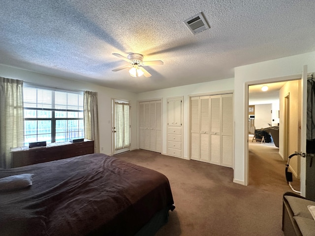 3864 Bear Head Rd, Crestview, FL 32539 - bedroom with dark carpet, multiple closets, a textured ceiling, and a ceiling fan