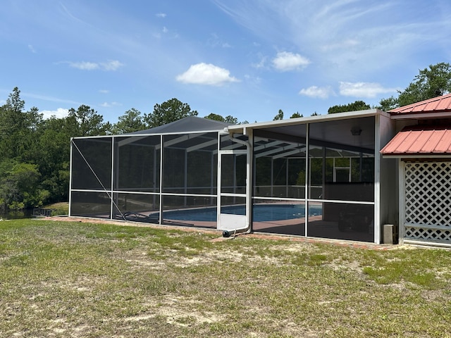 3864 Bear Head Rd, Crestview, FL 32539 - rear view of property with an outdoor pool, a yard, metal roof, and a lanai