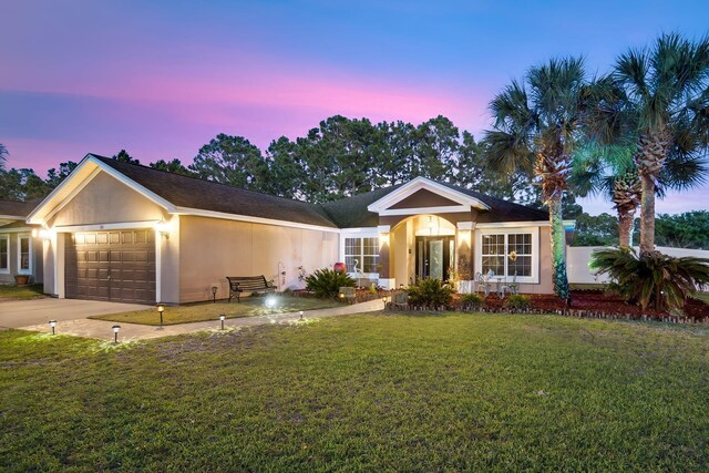 100 Kensington Cir, Panama City Beach, FL 32413 - ranch-style house featuring an attached garage, a yard, stucco siding, and driveway