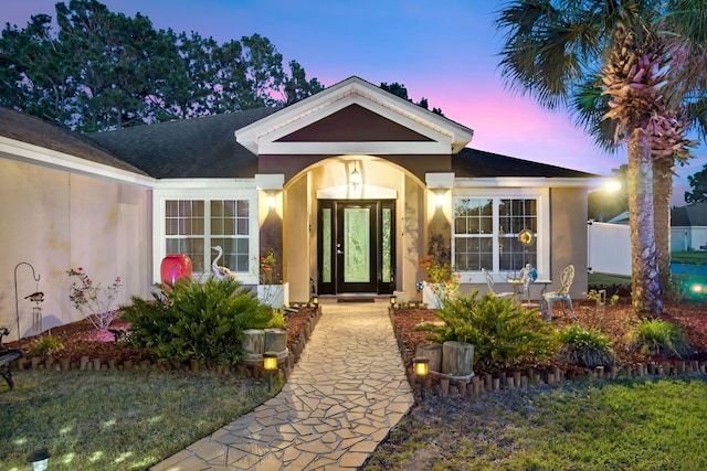 100 Kensington Cir, Panama City Beach, FL 32413 - exterior entry at dusk featuring stucco siding